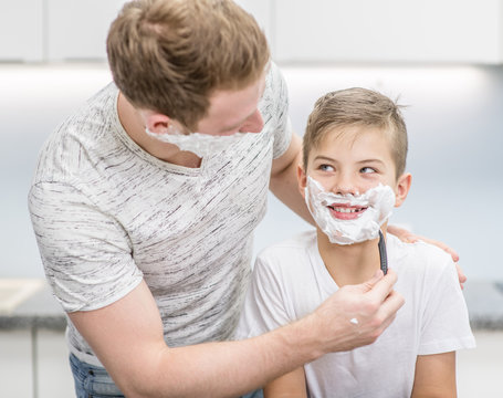 Father and son have fun while shaving at home