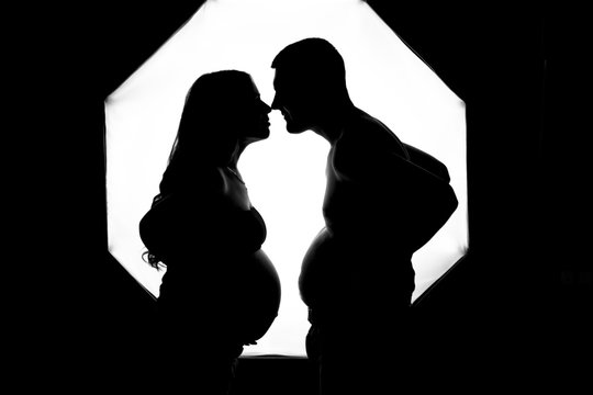 profile of a guy and a pregnant girl in a photo studio