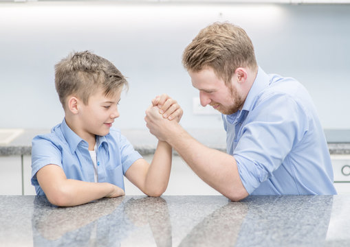 Father and son competing in arm wrestling at home