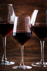 Wine glass. Selection of red wines on wine tasting. Dry, semi-dry, sweet red wine on old wooden table background. Copy space