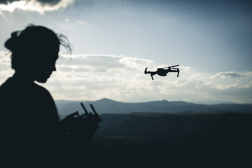 Fototapeta na wymiar Operador de drone volando en la naturaleza cerca de las montañas