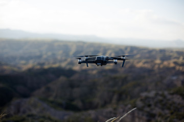 Fototapeta na wymiar Drone volando en la naturaleza cerca de las montañas