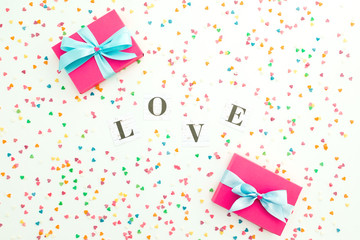 Valentines day composition with Love word and gift with confetti on white background. Flat lay