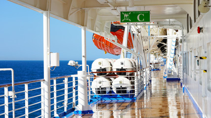 walk deck on a cruise ship. safety on the ship, lifeboat, liferafts, lifebuoys. liferaft station. blue ocean. white ship in the blue ocean. large cruise ship