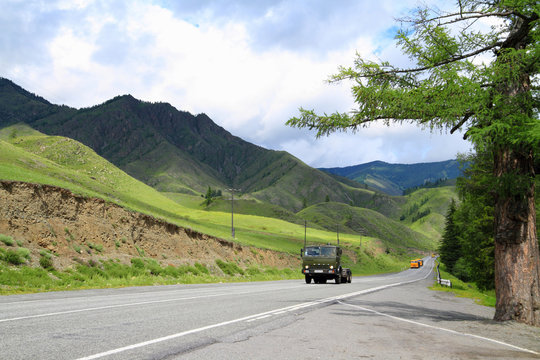 Landscape with passing cars on the road on a may day in the Altai Mountains in Russia