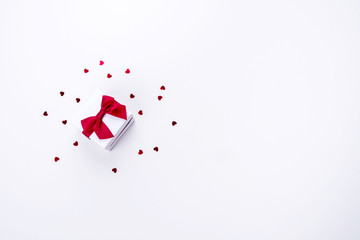 Small gift box and red little hearts on a white background