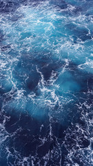 Dark water of the pacific ocean. Natural blue background. foam composition in the ocean. white sea foam, waves, storm. vertical photo