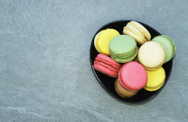 Colorful macarons on light grey background.