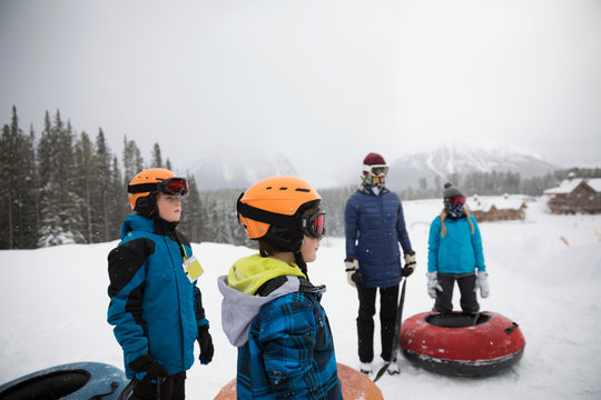 Family Inner Tubing In Snow At Tube Park