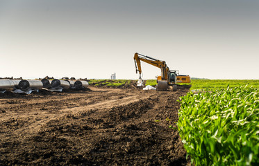 Crane digging a channel for gas pipeline