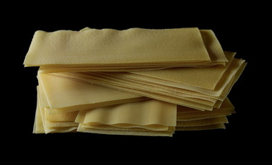 Uncooked Italian lasagna, pasta isolated on black background