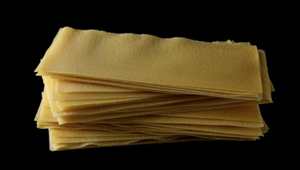 Uncooked Italian lasagna, pasta isolated on black background