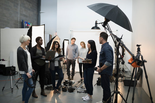 Photographers And Production Team Meeting, Preparing For Photo Shoot In Studio