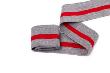 Gray knitted tape with a red stripe on a white background