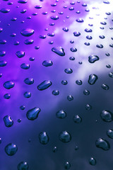 Pattern of water drops in realistic style on neon background. Abstract backdrop. Blue metal surface. Water texture.