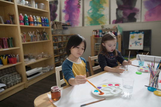 Preschool boy and girl painting in art classroom