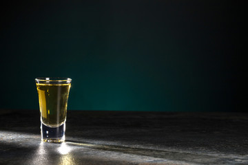 Portion of strong alcohol is brightly illuminated on a beautiful dark background. Copy space.