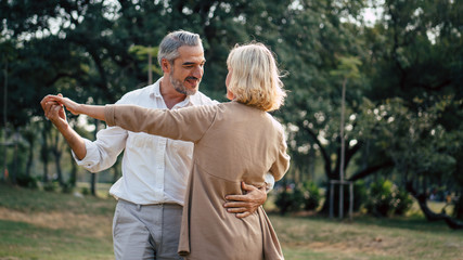Senior elegant caucasian couple dancing looking at each other feeling love and cherish on their...