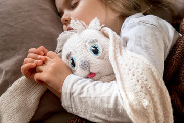 Pretty little girl hugging her toy rabbit