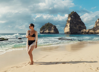 Fototapeta na wymiar Woman walking on a beach at Diamond Bay, Nusa Penida island, Indonesia