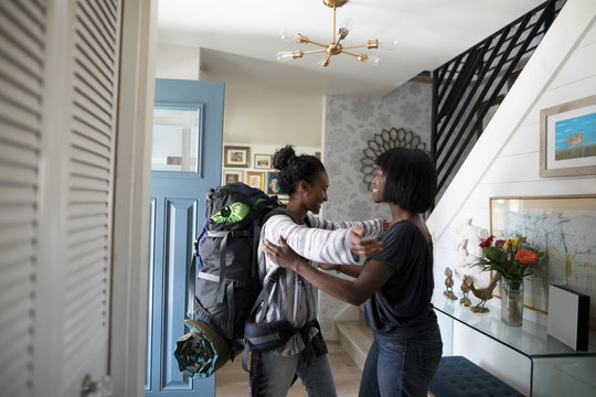 Affectionate mother saying goodbye to teenage daughter leaving for backpacking trip
