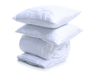 Folded white soft warm blanket with pillows on white background isolation