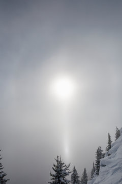 Sun breaking through clouds over snow