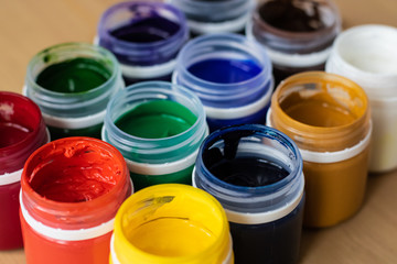  Paint brushes and watercolor paints,  tempera paints on the table in a workshop, selective focus, close up, on wooden background.