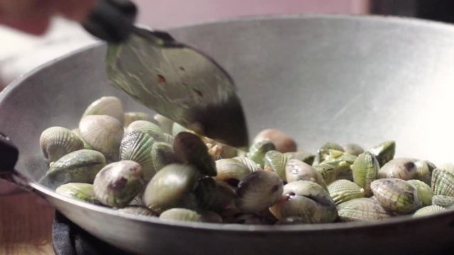 Stir Fried Quahaug Shell with Garlic in Hot Frying Pan, Gas Stove
