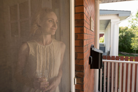 Serene woman standing at porch screen