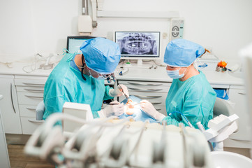 Dentist during a dental intervention with a patient. Dental clinic concept.