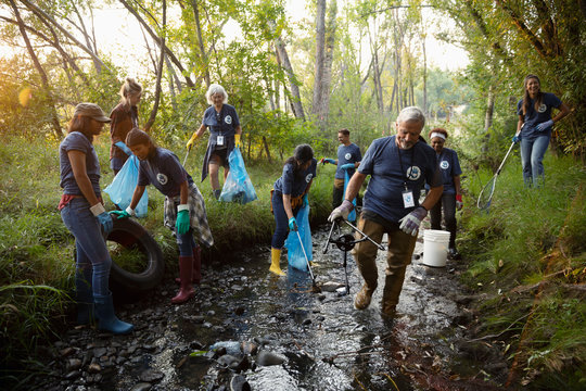 People volunteering, cleaning up garbage in stream
