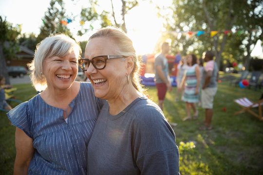 Happy, carefree senior women friends at summer neighborhood block party in park