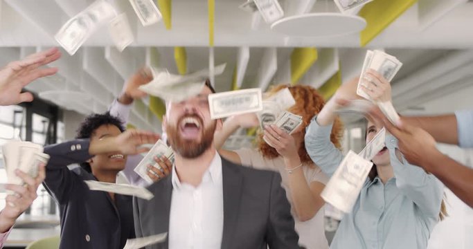 Handsome male chief dancing and making yes gesture in circle of his teammates. Successful business staff rejoicing, dancing, having good mood and scattering money. Concept of victory.