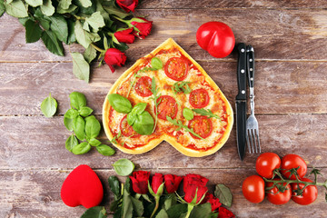 pizza Heart shaped margherita with tomatoes and mozzarella vegetarian. Food concept of romantic love pizza for Valentines Day.