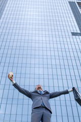happy business man standing near modern building.