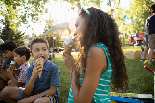 Kids Eating Ice Cream Cones At Summer Neighborhood Block Party In Park