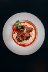 a piece of cooked beef with cheese and sauce