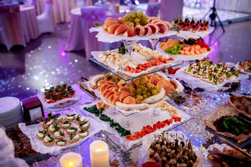 great attractive set of canapes with vegetables, cheese, fruits, berries, salami, seafood, meat and decoration on wedding