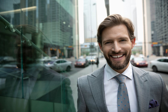 Portrait smiling, confident businessman on urban sidewalk