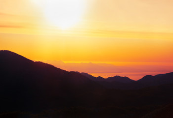 Fototapeta premium scenery with morning sun over the sea and mountains