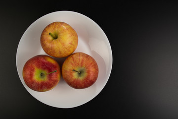 Red apples lie on a plate