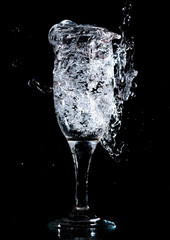 Water with splashes in a glass on a black background
