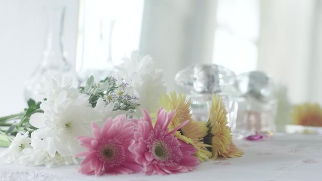 A Bouquet of Bloom Pink and Yellow Daisy Flower on Dressing Table in White Room 