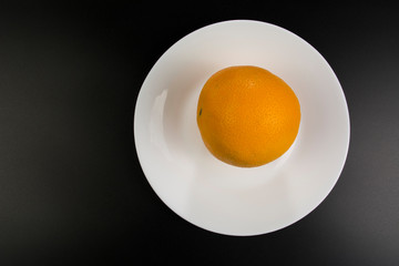 Juicy orange lies on a plate