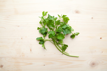 Green Parsleys on a wooden background.