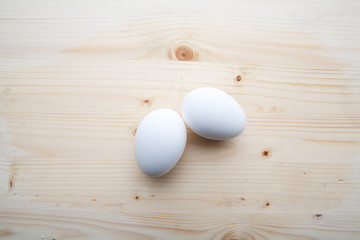 Two white egs on a wooden background.