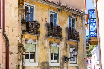 Fototapeta na wymiar Old building with its damaged balconies in an old district of Lisbon