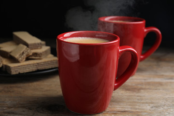 Delicious coffee and wafers on wooden table