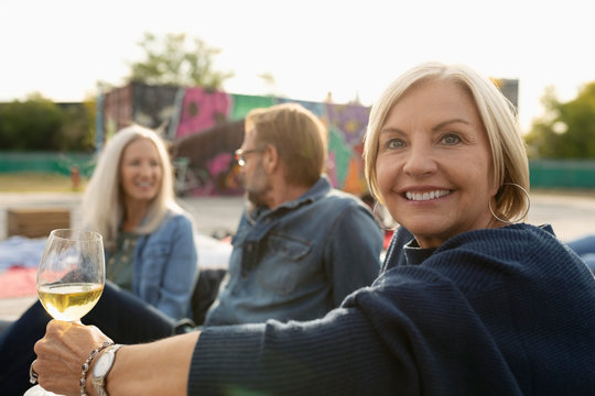 Portrait Smiling Mature Woman Drinking White Wine At Movie In The Park